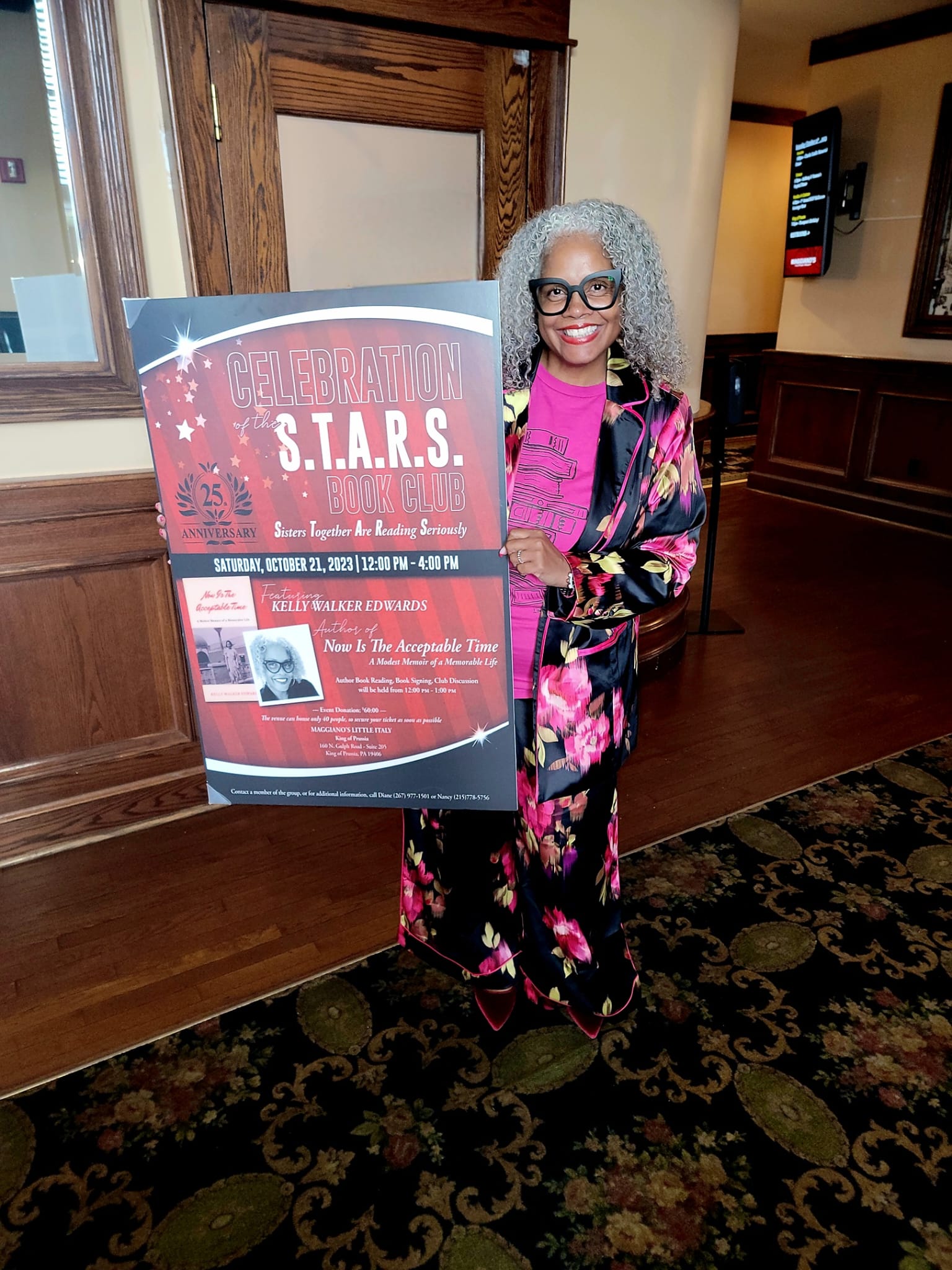 Kelly Walker Edwards standing beside the event poster for the S.T.A.R.S. Book Club 25th anniversary celebration